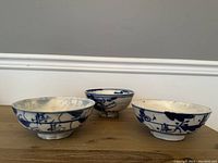 Three blue and white antique Chinese porcelain bowls shown side by side, displaying their size and shape.