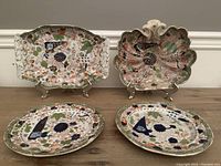 All four Mason's Ironstone dishes displayed together, two rectangular serving dishes and two oval plates with colorful floral and bird painted designs.