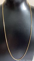 28-inch gold-colored box chain necklace shown on display bust.