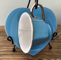 Teal blue heart shaped teacup on matching saucer showing exterior and shape