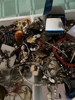 Overview of assorted jewelry with visible boxed items and loose pieces including beaded necklaces, brooches, and bracelets.