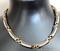 Front view of black enamel and rhinestone linked panel necklace on black mannequin bust showing the design and clasp