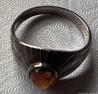 Top-down view of sterling silver ring size 8 with amber gemstone and textured sunburst band design.