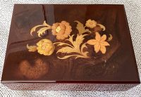 Top view of vintage wooden jewelry box showing floral inlay design on lid.