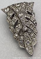 Close-up front view of the leaf-shaped scarf clip showing rhinestone detailing.