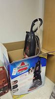 Upright cleaner unit in cardboard sleeve inside original shipping box