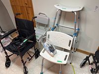 Wheelchair, shower chairs, shower stool and commode in a room with linoleum floor