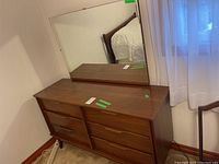 Overall view of the six-drawer walnut dresser with matching mirror in room setting