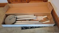 Westminster chimes laid out inside original cardboard box showing aluminum tubes, wooden suspension top and hanging cord