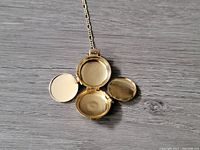 Close-up of the four open chambers of the locket pendant, showing smooth interior surfaces for photos.