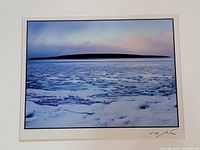Close up of the framed photograph depicting Giant's Tomb Island surrounded by ice and frozen water under a pastel sky.