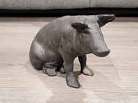 Front view of the large cast iron piggy bank showing overall shape, detailing, and surface condition.