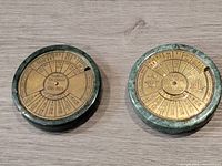 Photo shows both marble and brass perpetual calendars side by side on a wooden surface.