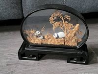 Front view of the San You panda diorama inside the glass oval dome with carved foliage and two panda figurines.