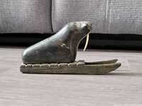 Side view of the Inuit soapstone walrus carving on sled base showing missing tusk and overall shape.