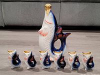 Full view of the USSR hand painted fish decanter with six matching fish-shaped cups, showing size and arrangement