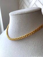 Front view of the 18k gold-plated braided rope chain necklace displayed on a necklace bust, showing the thick and well-crafted texture.