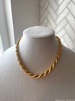 Full view of the gold plated Milor bronze rope chain necklace displayed on a beige fabric bust, showing twisted rope design in gold tone.
