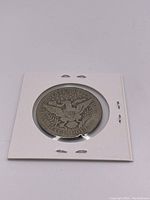 Reverse of 1912 Liberty Head Half Dollar coin showing eagle with shield and stars, encased in protective holder.