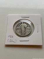 Obverse side of the 1928 Silver Liberty Quarter showing Lady Liberty standing with shield and olive branch, encased in protective flip.