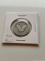 Close-up photo of the reverse side of the 1929 US Liberty Quarter showing an eagle in flight and inscriptions.