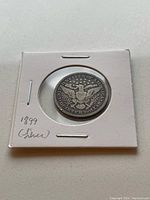Reverse side of 1899 Barber silver quarter showing eagle design with inscriptions.