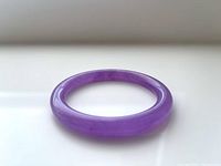 Side angle showing thickness and polished surface of the lavender jade bangle.