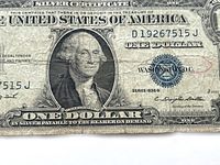 Front of the 1935G Series one dollar bill showing George Washington's portrait and treasury seal, with visible marks and worn edges.