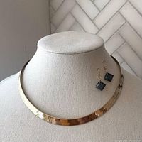 Full view of necklace and earrings on display bust showing the herringbone pattern and black CZ earrings.