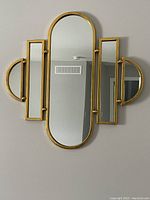Frontal view of gold-toned five-panel Art Deco wall mirror hanging on wall