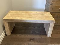 Front view of mango wood bench against wall on hardwood floor