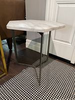 Side view of the hexagonal white marble side table showing metal supports and overall design.