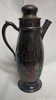 Full view of copper pitcher with handle, spout, and lid, showing overall shape and condition with visible patina.