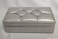 Silver tufted jewelry box with rhinestone embellishments on lid.