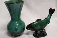 Lot showing the green glazed vase with bulbous base and flared top, along with the green fish figurine on base.