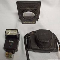 Vivitar 2800 flash, Lindahl Specialties lens shade, and Asahi Pentax Spotmatic camera in leather case
