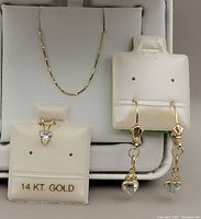 Set displayed on presentation holders showing chain, pendant and earrings.
