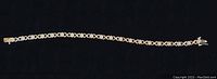 Full length view of the bracelet against a black background showing alternating two-tone links and flower diamond arrangements.