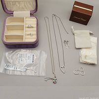 Full lot displayed showing jewelry pieces alongside storage boxes and packaging, white background