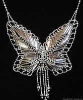 Front view of delicate sterling silver butterfly pendant with beaded accents and dangling bead strands on linked bead chain.