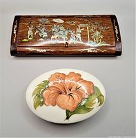 Photo showing both the wooden jewelry box with shell inlay and the Moorcroft oval keepsake with hibiscus motif side by side from front view.