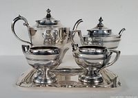 Silver plated coffee and tea set shown on white background including coffee pot, tea pot, creamer, sugar bowl, and rectangular tray.