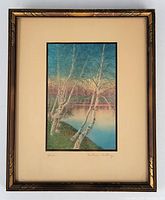 Full view of framed, matted photograph depicting birch trees by a lake with sunset, signed and titled below image.