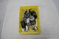 Top view of a yellow plastic container holding eight assorted Mitutoyo measuring instruments including digital bore gauges and micrometers.