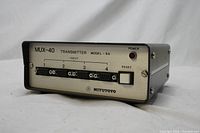 Front view of Mitutoyo MUX-40 Transmitter Model-SA showing four input DB connectors, power LED, reset button, brand and model