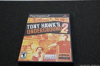 Front cover of Tony Hawk's Underground 2 game case for PlayStation 2, showing title and artwork with two skateboarders.