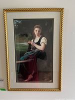 Full view of the framed and matted print depicting a young girl knitting, showing the wooden frame and the matting around the print.