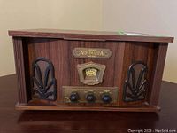 Front angled view of wood grain TEAC Nostalgia GF-180 record player showing front speakers and control knobs.