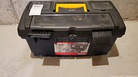 Closed view of black and yellow Keter heavy-duty plastic toolbox with sticker on top showing brand and product info.