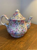 Front and side view of the floral chintz tea pot showing full body, handle, and lid.